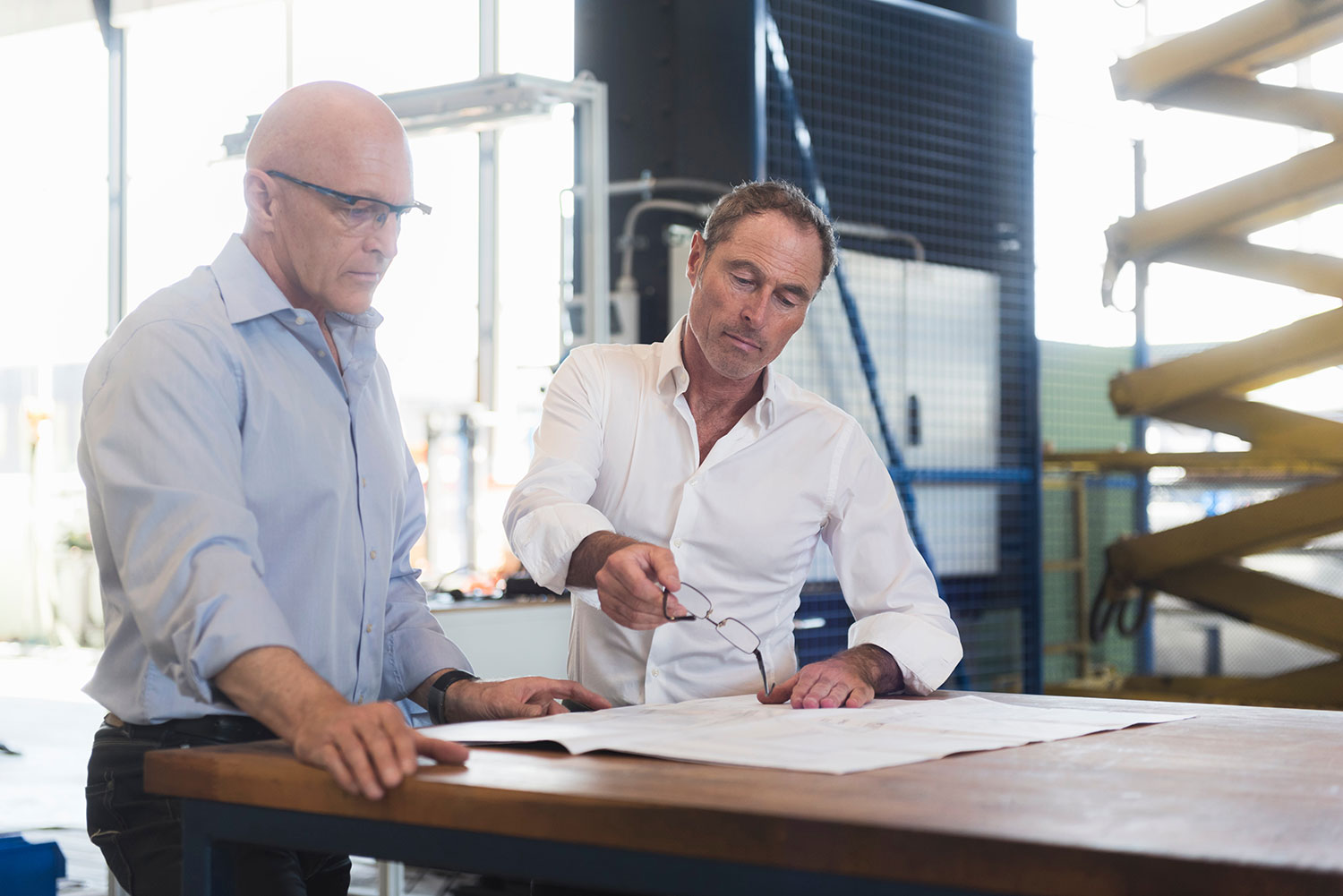 An image of 2 guys looking at engineering paper - engineering projects