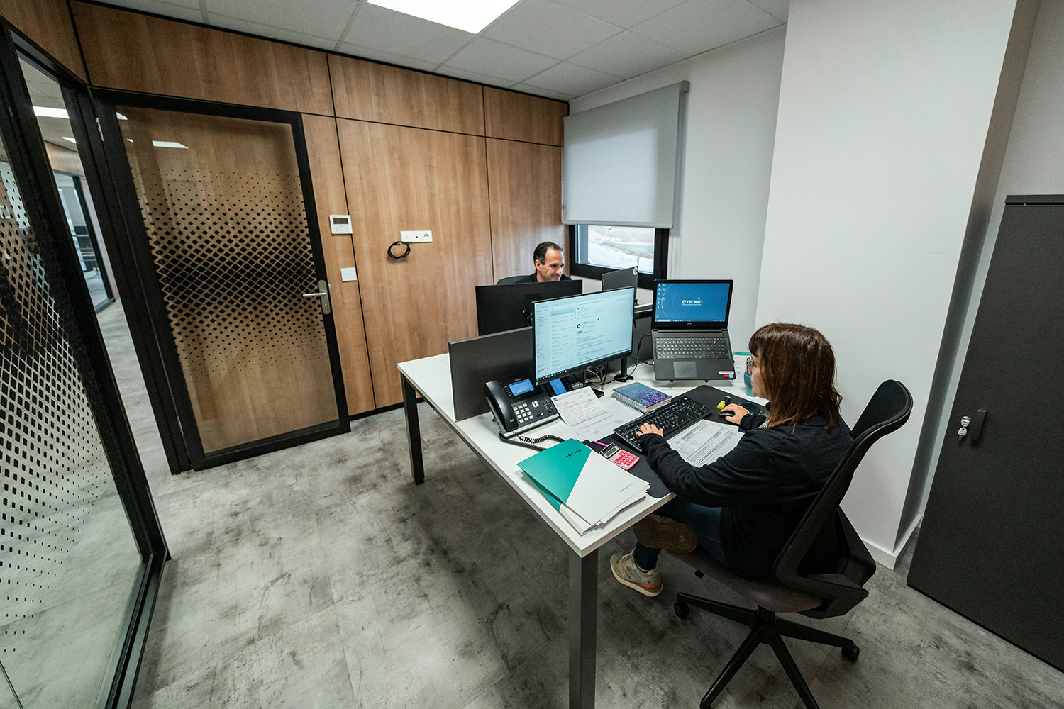 Two men looking at technical designs on a table and pointing to them.